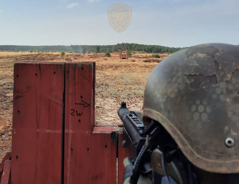 Soldat ziel mit MG auf ein Ziel in weiter Entfernung. Karge Landschaft auf einem Truppenübungsplatz